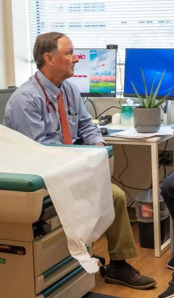 A physician at a desk in an exam room