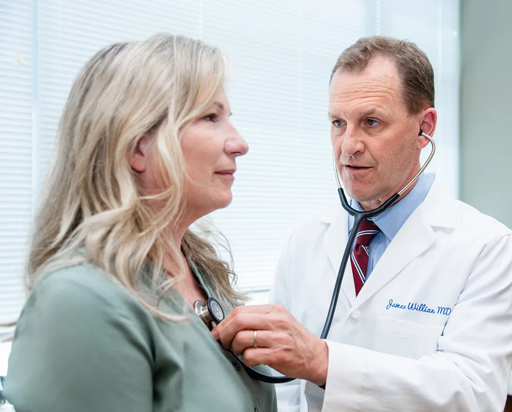 A physician listening to a patient’s heart during a visit