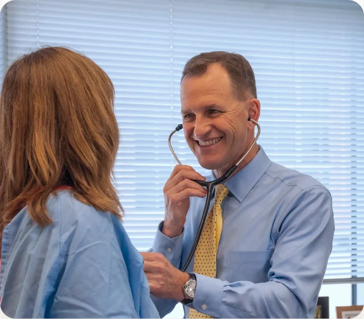 A physician listening to a patient with a stethoscope